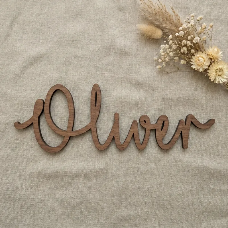 Walnut name sign reading Oliver in the Scribble font, on natural linen